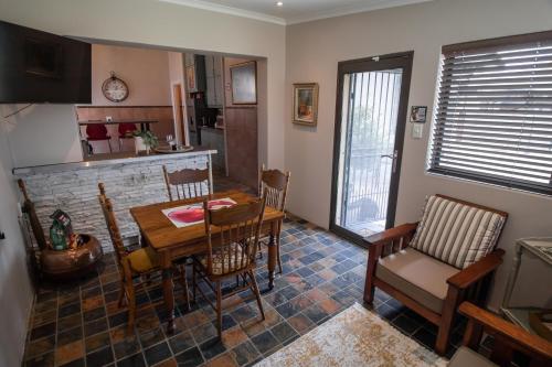 una cucina e una sala da pranzo con tavolo e sedie di SUMMER PLACE a Harrismith