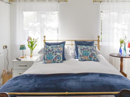 Llabedr-Dyffryn-Clwyd的住宿－Wisteria Lodge At The Shipon，一间卧室配有一张带蓝色枕头的大床