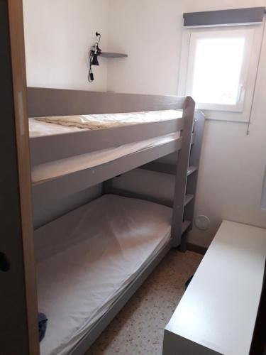 deux lits superposés dans une chambre avec fenêtre dans l'établissement Le Bois Couchant, à La Grande Motte