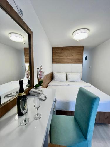 a hotel room with a bed and a table with wine glasses at Hotel Villa Garden Ulcinj-Ulqin in Ulcinj