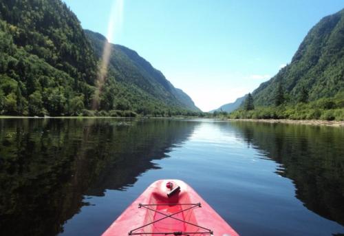 a person in a red kayak on a river at Condo 58 Chemin de la Corniche by Les Chalets Alpins in Stoneham