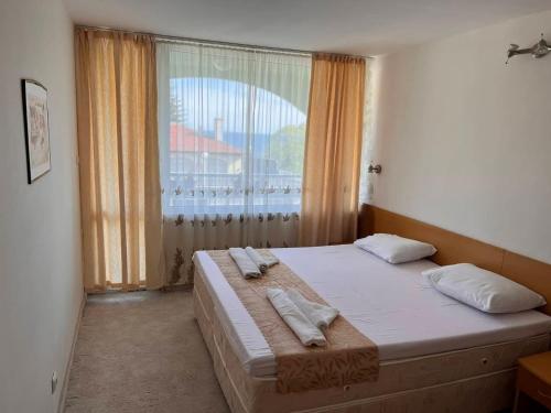 ein Schlafzimmer mit einem großen Bett mit Handtüchern darauf in der Unterkunft Хотел Диамант Hotel Diamond in Baltschik