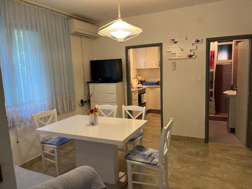 a kitchen and dining room with a white table and chairs at Villa Vesna Nin in Nin