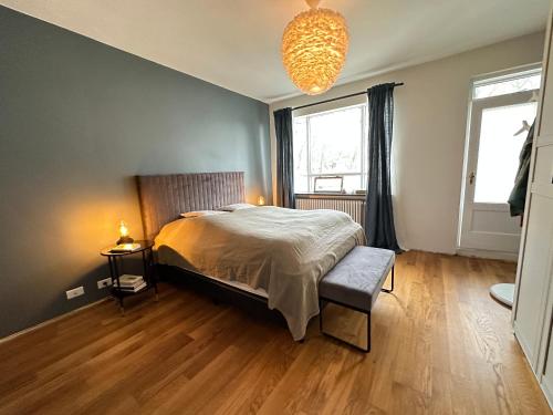 a bedroom with a bed and a chandelier at Apartment in Hagamelur - Birta Rentals in Reykjavík