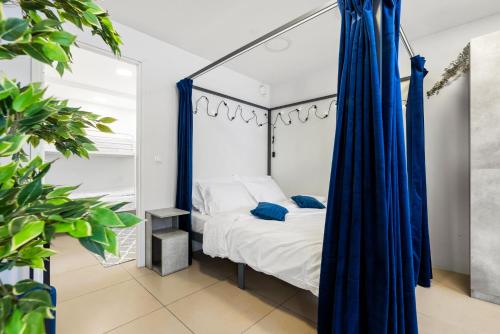 a bedroom with a canopy bed with blue curtains at Sirena Apartment - Self check-in and free parking in Tallinn