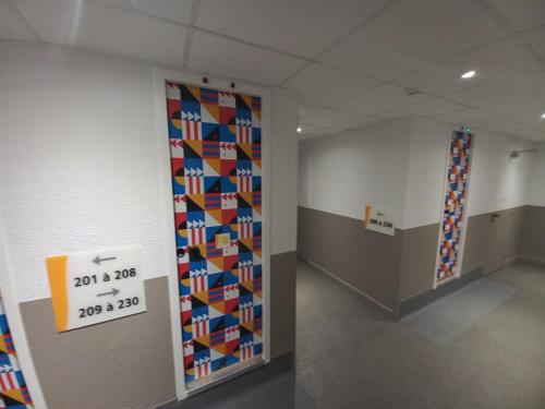 a room with a wall covered in colorful tiles at Premiere Classe Evry Sud - Mennecy in Ormoy