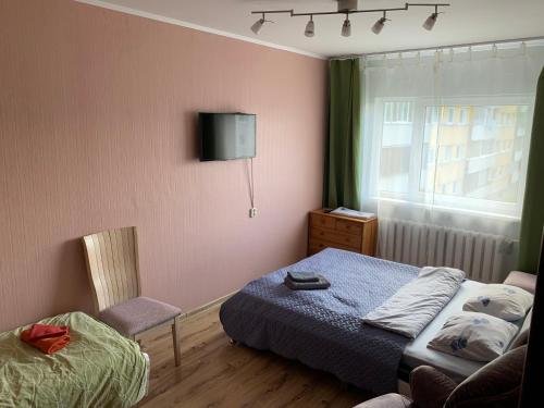 1 dormitorio con 1 cama y TV en la pared en Mõisavahe 30 two big beds 1 single bed en Tartu