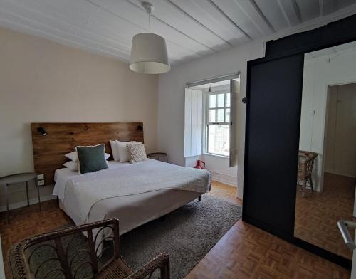 1 dormitorio con 1 cama grande y espejo grande en Historic Torres Vedras en Torres Vedras