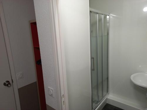 a bathroom with a glass shower and a sink at Premiere Classe Evry Sud - Mennecy in Ormoy