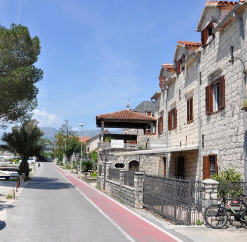 an old stone building with a bike parked next to a street at Apartments Vujošević in Kotor