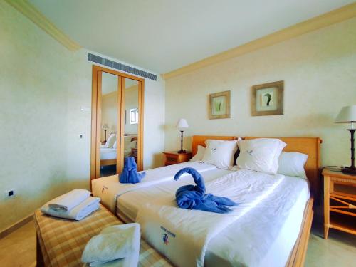 un dormitorio con dos cisnes azules en una cama en El Nautico Suites, the beachfront Paradise, en San Miguel de Abona