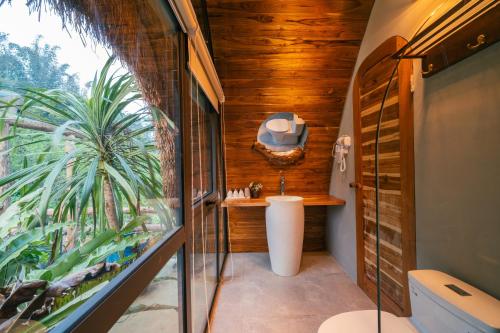 a bathroom with a toilet and a large window at Hippie Home in Mộc Châu