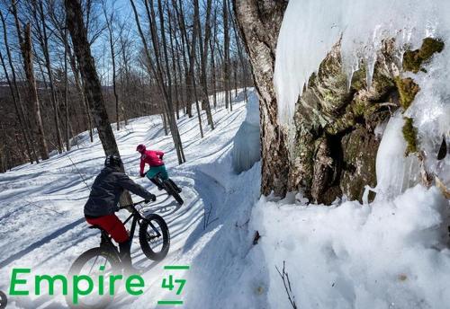 two people riding a bike in the snow at Condo 203 33 Chemin du Hameau by Les Chalets Alpins in Stoneham
