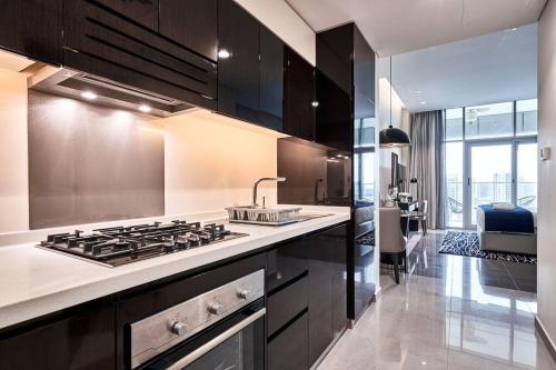 a kitchen with a stove and a sink in it at 5* Studio, 10min walk to Dubai Mall, 1min Bay Sqr in Dubai