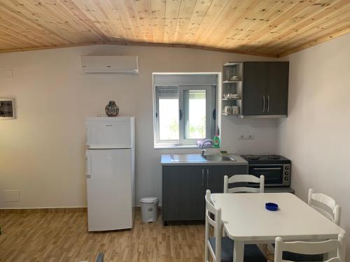 a kitchen with a white refrigerator and a table at Villas Ermali in Ksamil