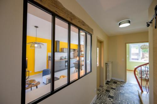 a hallway with a room with yellow walls and windows at Chez Odette - SPA, Barbecue, Parking in Albi
