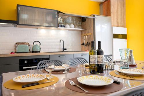 a kitchen with a table with plates and wine bottles at Chez Odette - SPA, Plancha, Parking in Albi