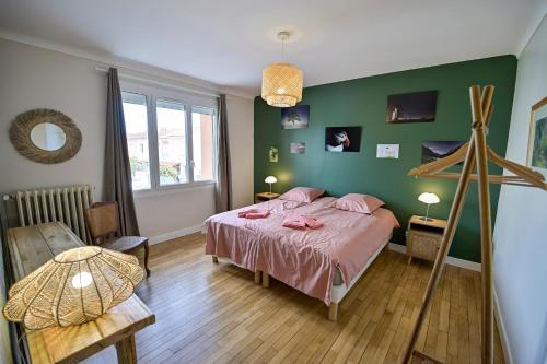 a bedroom with a bed and a green wall at Chez Odette - SPA, Plancha, Parking in Albi