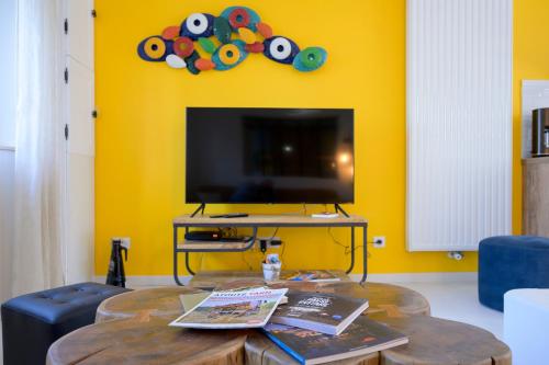 a living room with a table and a tv at Chez Odette - SPA, Plancha, Parking in Albi