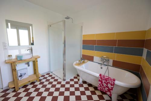 a bathroom with a tub and a checkered floor at Chez Odette - SPA, Plancha, Parking in Albi