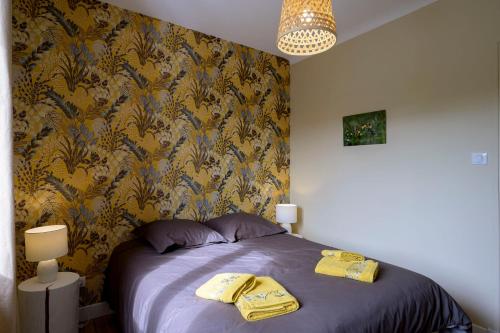 a bedroom with a bed with yellow towels on it at Chez Odette - SPA, Plancha, Parking in Albi