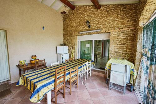 una habitación con un grupo de mesas y sillas en Maison provençale dans un cadre bucolique, en Grignan