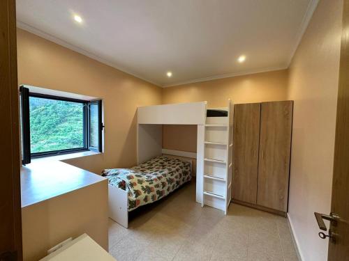 a small bedroom with a bunk bed and a window at VViP Vila Madeira in São Vicente