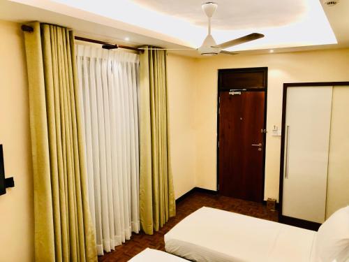 a bedroom with a bed and a ceiling fan at Tropic Inn - Mount Lavinia in Mount Lavinia