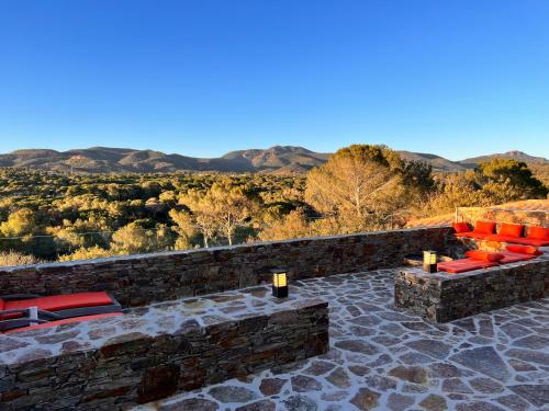 a patio with red chairs and mountains in the background at Villa familiale avec vue imprenable in Saint-Raphaël