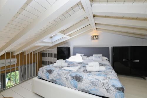 una camera da letto con un grande letto in una stanza bianca di Acquarius Resort Sirmione - MGH a Sirmione