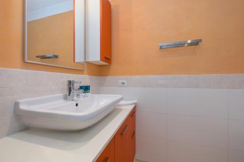 een badkamer met een wastafel en een spiegel bij Acquarius Resort Sirmione - MGH in Sirmione