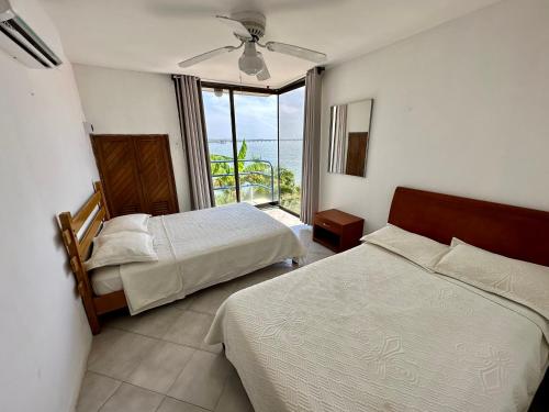 a bedroom with two beds and a view of the ocean at Casa Miramar in Santa Marta