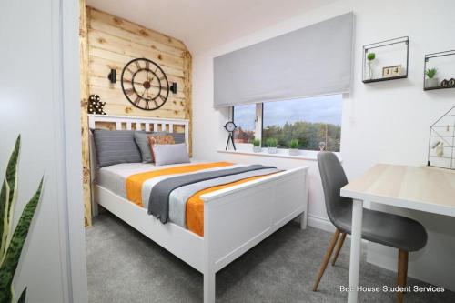萊斯特的住宿－Leicester City Apartments，一间卧室配有一张床、一张书桌和一个窗户。