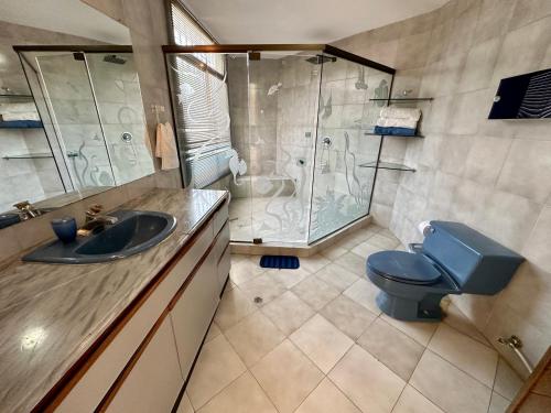 a bathroom with a blue toilet and a shower at Casa Miramar in Santa Marta