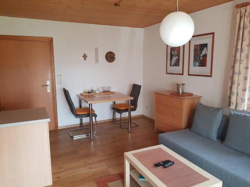 ein Wohnzimmer mit einem Sofa und einem Tisch in der Unterkunft Ferienwohnung am Altenstein in Grafenau