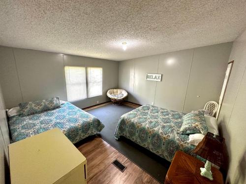 a bedroom with two beds and a table in it at Orange Beach! Spacious mobile home near the beach! in Orange Beach