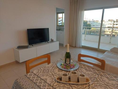 a living room with a table with a bottle of wine at Apartamentos CT in Salou