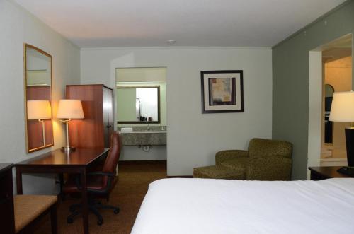 a hotel room with a bed and a desk and chair at Quality Inn & Suites Covington in Covington