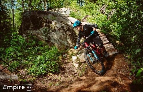 a man riding a bike on a dirt trail at Chalet 23 Chemin des Quarante by Les Chalets Alpins in Stoneham