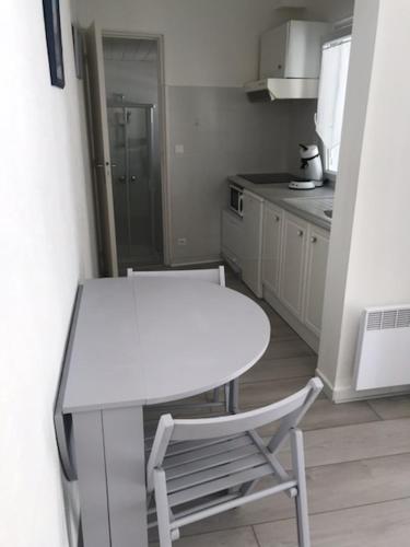 une petite cuisine avec une table blanche et une chaise dans l'établissement MAISON SAINT PALAIS SUR MER, à Saint-Palais-sur-Mer