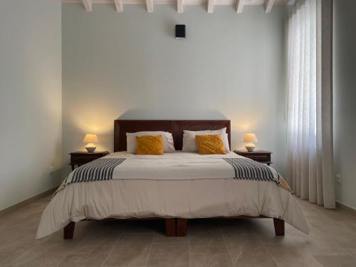 a bedroom with a bed with two lamps on two tables at Quinta do Areal in Lousã