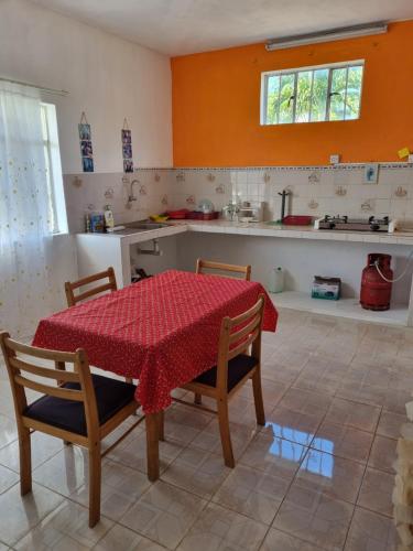 a kitchen with a table and two chairs and a red table cloth at Le Soleil Villa in Centre de Flacq
