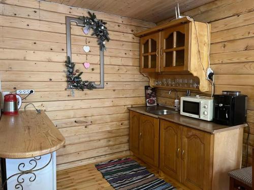 una cucina con pareti in legno e bancone con forno a microonde di Чан Баня Басейн a Mizhhirya