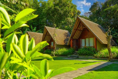 a row of cottages with green grass and trees at Bintang House in Kintamani