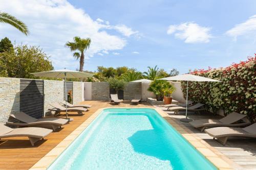 - une piscine avec des chaises et des parasols à côté d'une terrasse dans l'établissement Résidence Marina Rossa, à Porto-Vecchio