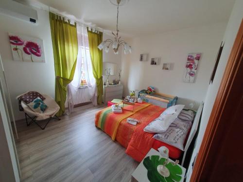 een slaapkamer met een bed, een stoel en een raam bij Ai piedi del Centro Storico in Castiglione del Lago