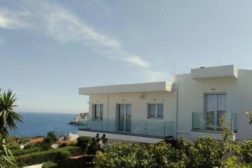 a white house with a view of the ocean at Chatzidakis Apartment/Inspiration harmony in Lygaria