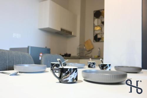 a table with plates and cups on top of it at Homesuite' Home at Jesselton Quay in Kota Kinabalu