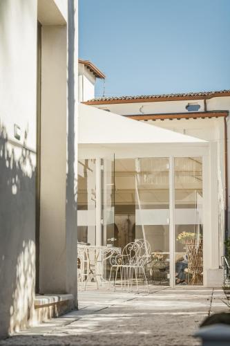 a patio with chairs and tables in a building at Hotel Palazzo Novello in Montichiari