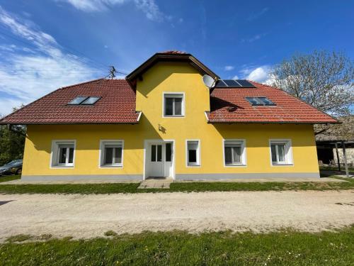 uma casa amarela com um telhado vermelho em Ferienwohnung Igerc em Feistritz ob Bleiburg